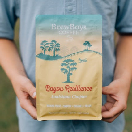 Hands holding a bag of BrewBoys Bayou Resilience caramel pecan coffee