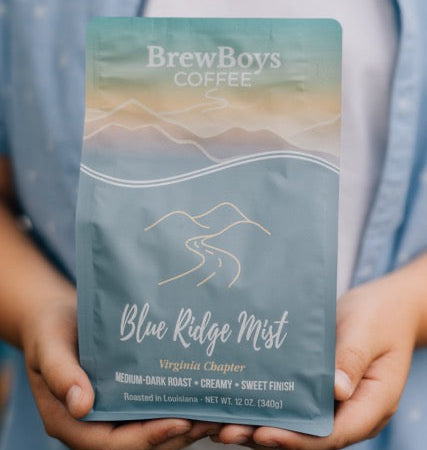 Hands holding a bag of BrewBoys Blue Ridge Mist medium-dark roast coffee