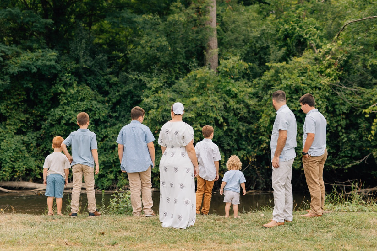 The Martin family standing together at the river's edge, looking out at the water