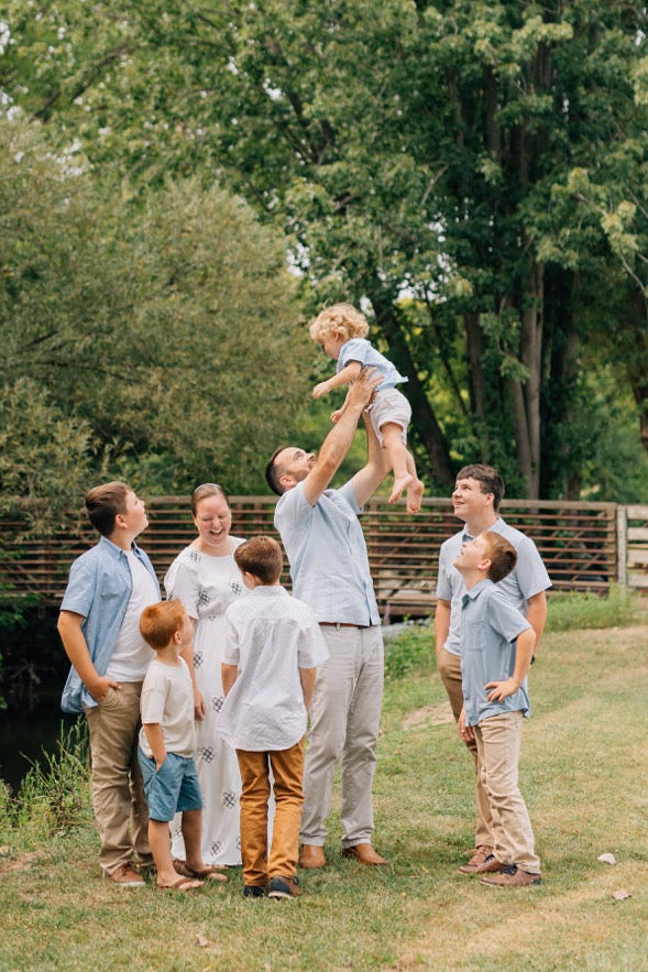 The Martin family laughing together as dad lifts the youngest son overhead